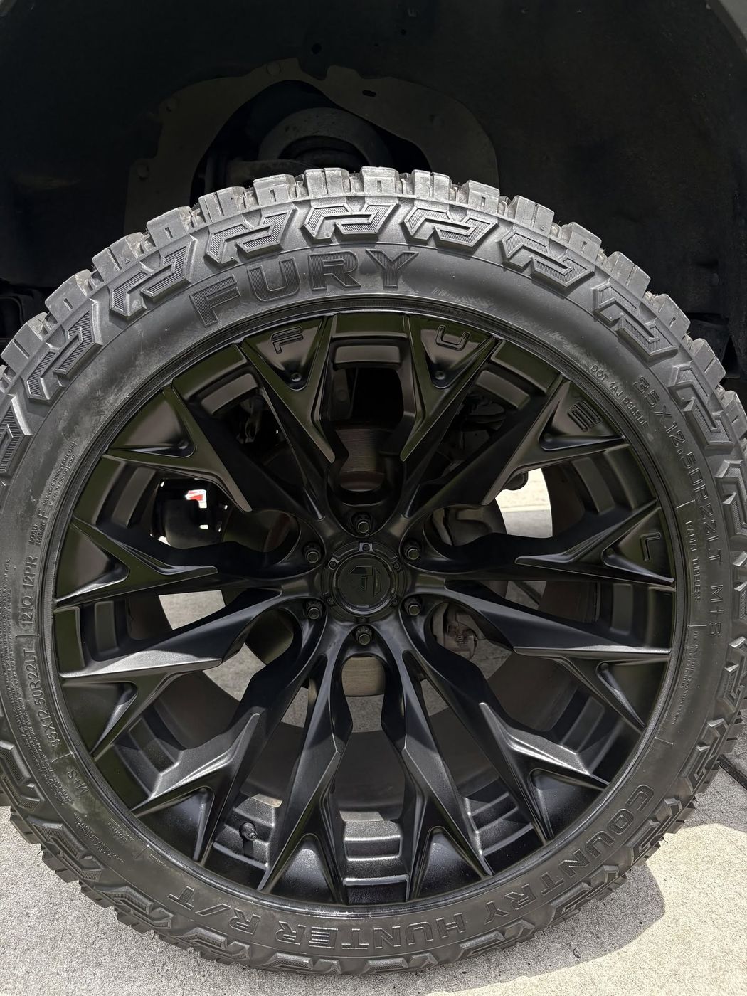 Zwart gespoten velg met diepe glans, klaar na de behandeling